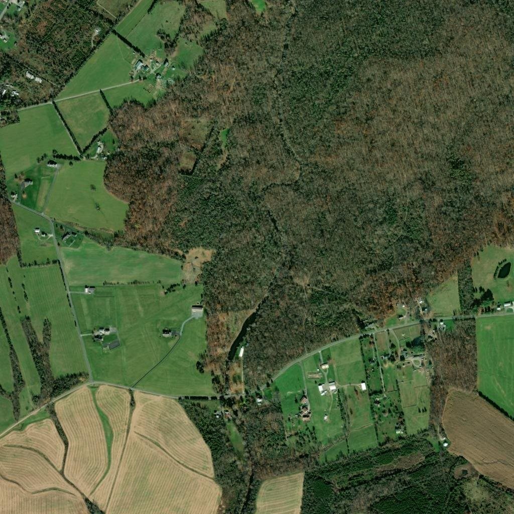Wide aerial view of the wooded park and surrounding farmland